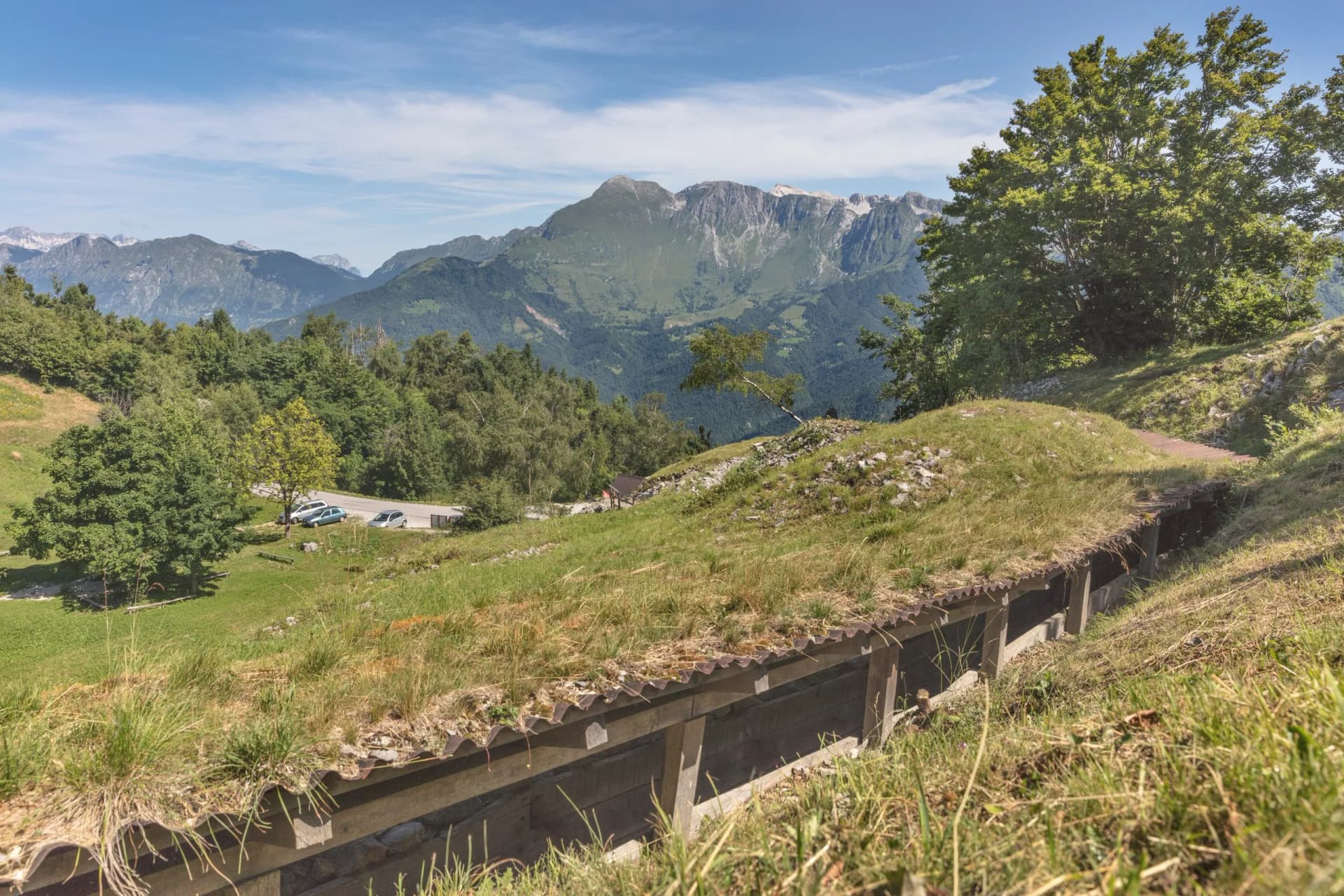 Trench from the First World War at Isonzo Front, grassy hillside overlooking mountains.