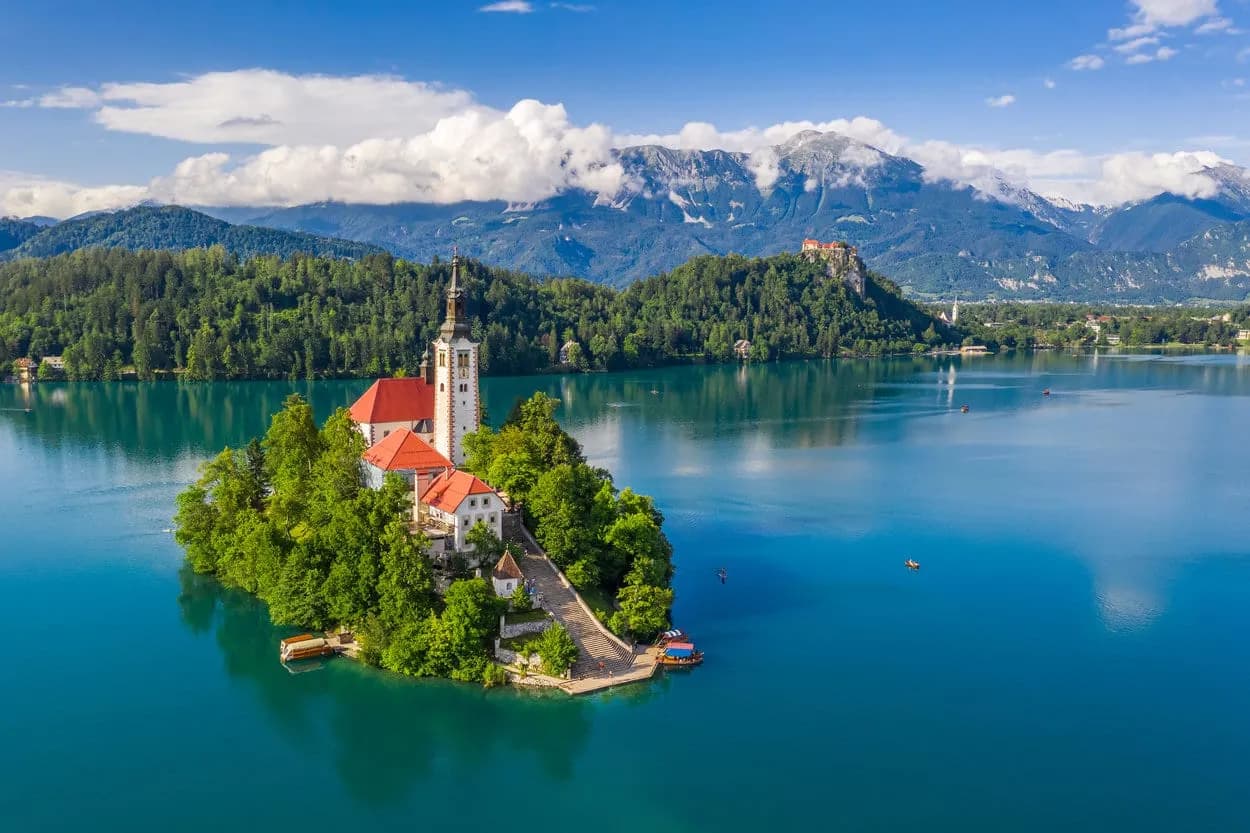 Church on island in Lake Bled with Julian Alps in background, Slovenia