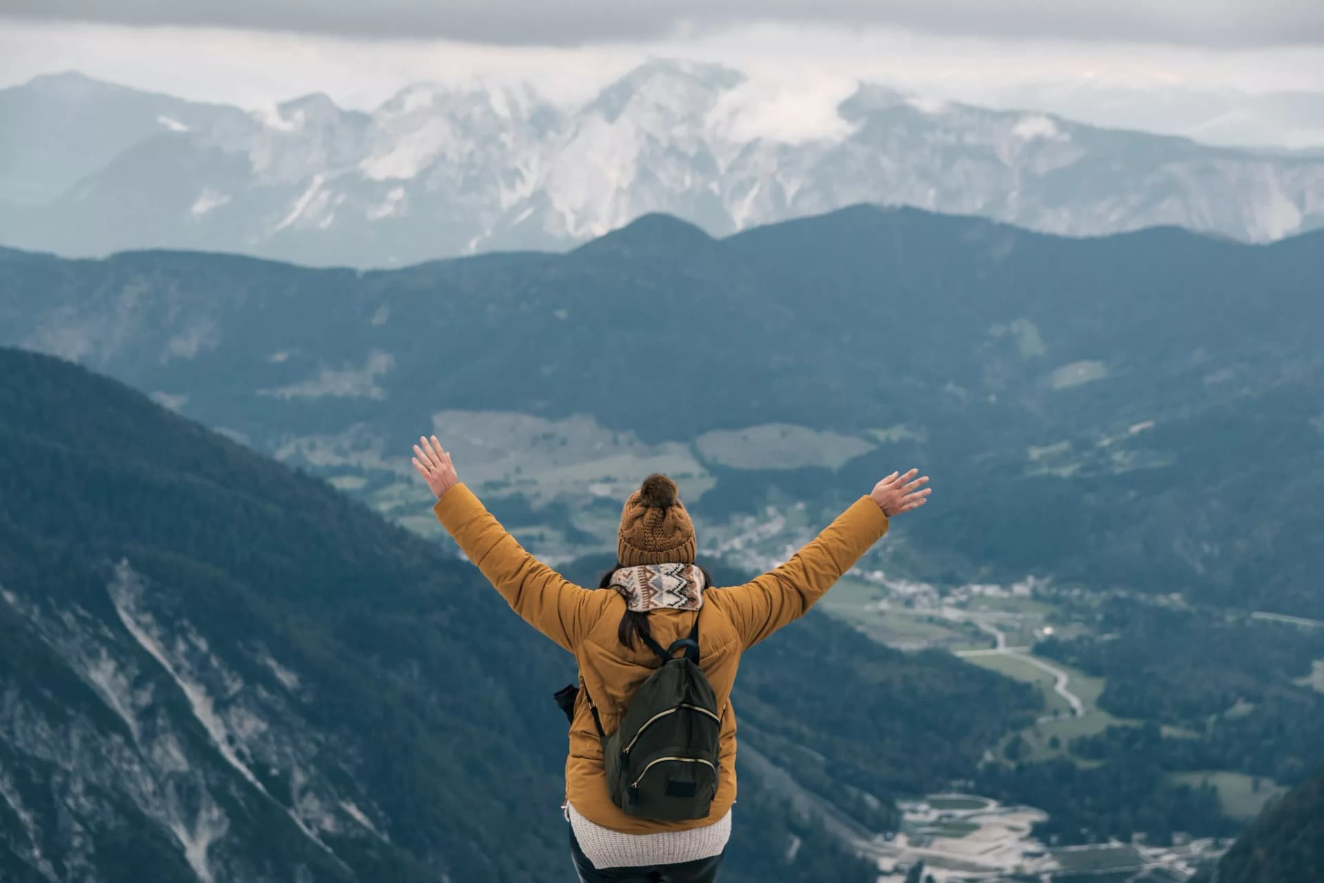 A hiker with outstretched arms at Slemenova spica in the Julian Alps - the concept of freedom