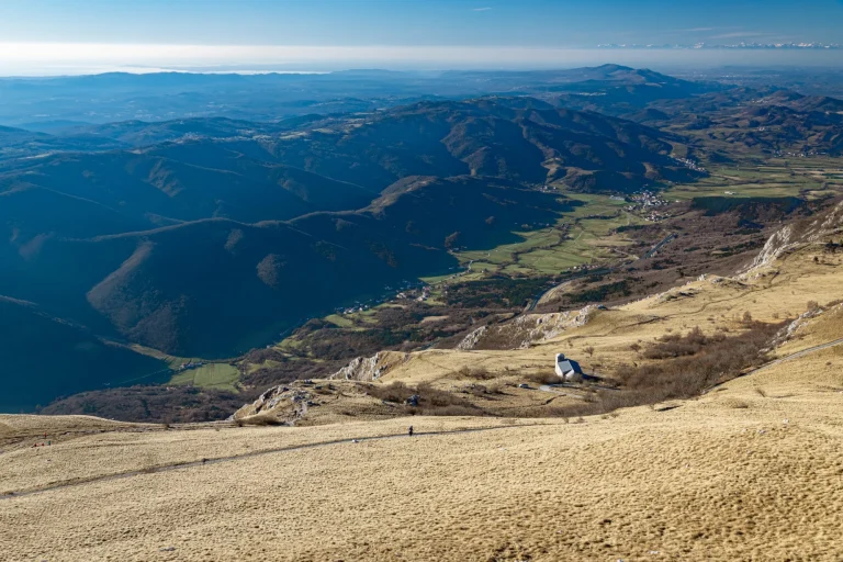 Het uitzicht vanaf de top van de Nanos berg en Vipava vallei met de stenen kerk van st. Heronim, Slovenië